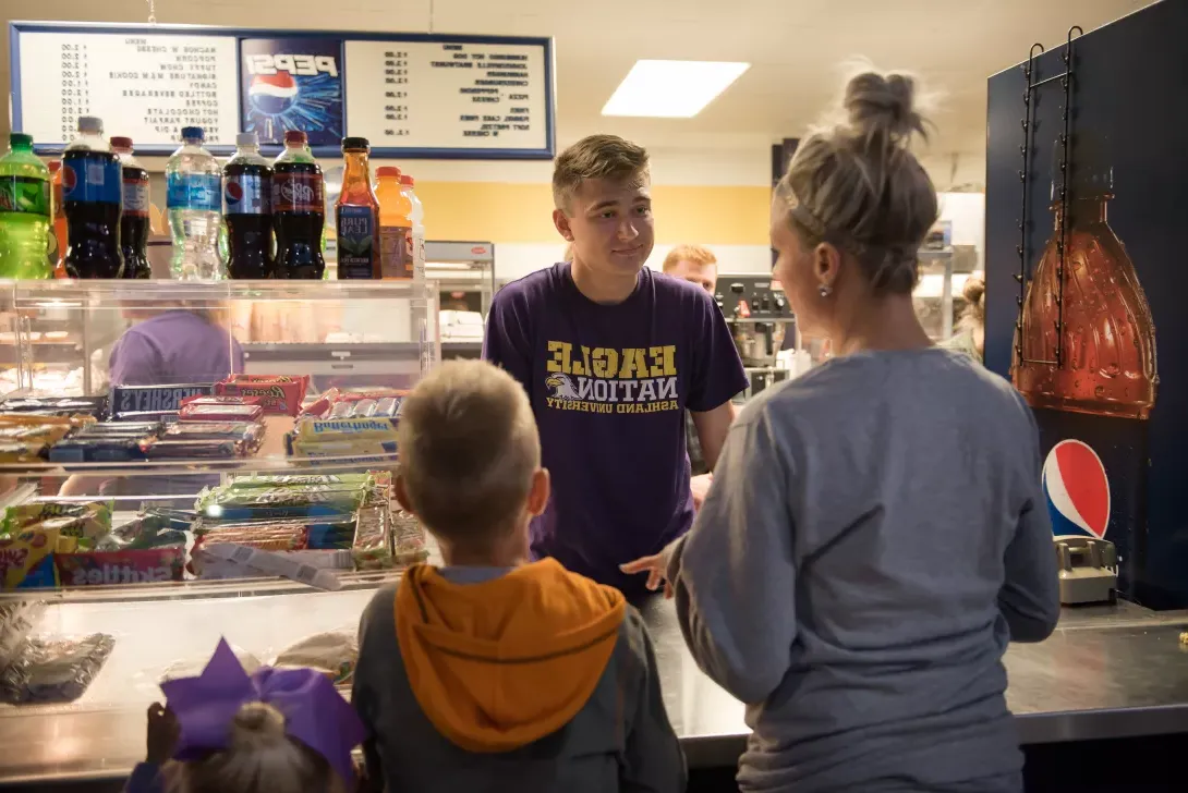 A mother and her son purchase items at Talons Concessions during a game